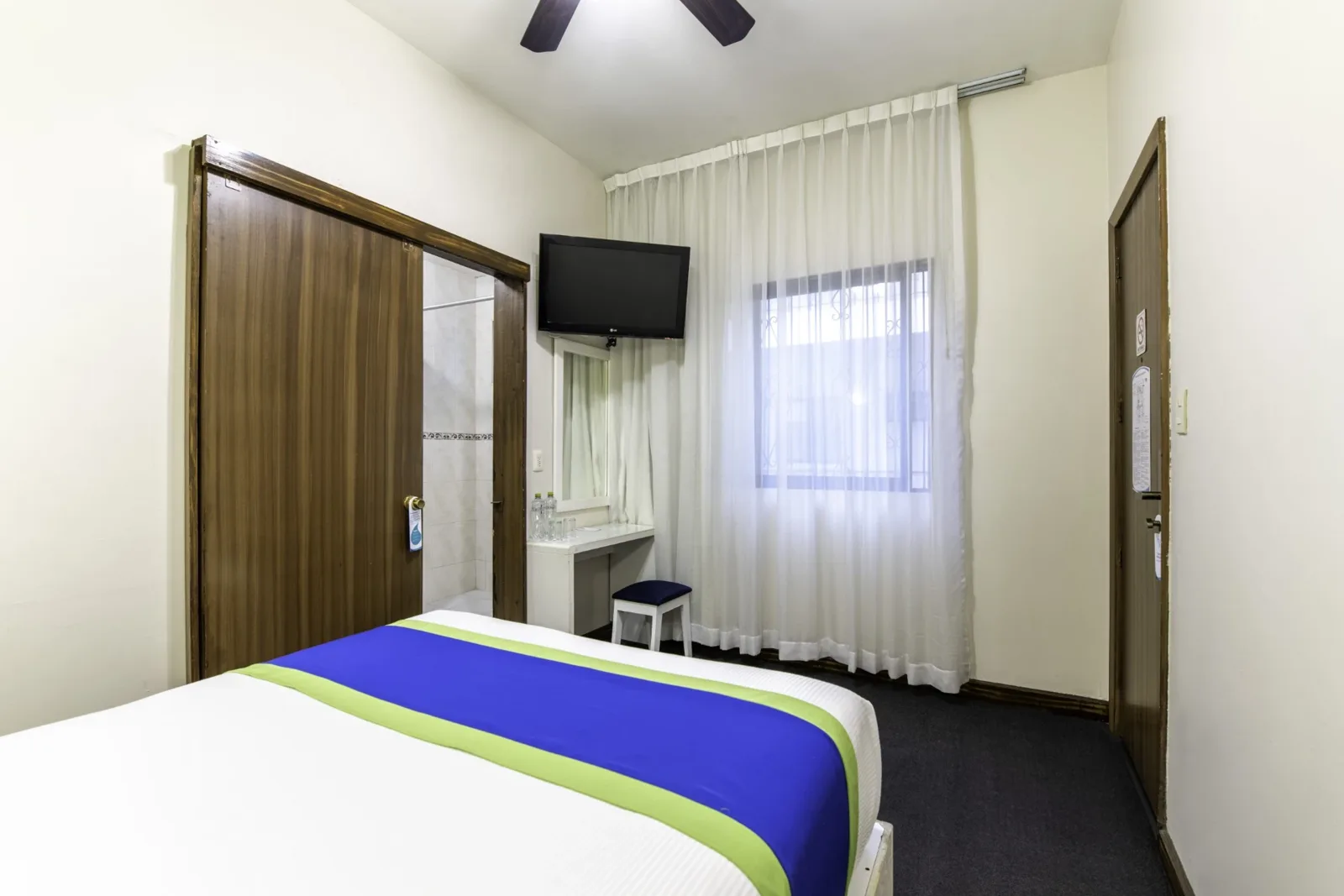 Room with ceiling fan, TV and desk
